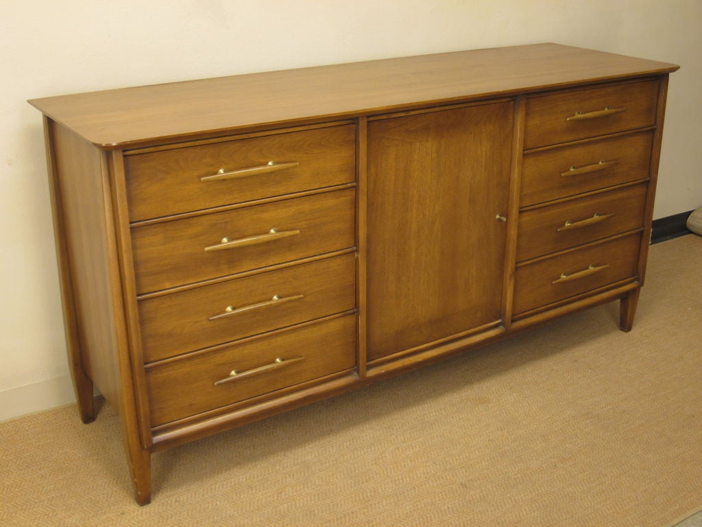 Mid Century Modern solid walnut dresser or credenza in the style of Paul McCobb or Robsjohn Gibbings. Original brass and wood drawer pulls. Very high quality craftsmanship. Made by the Davis Cabinet Company of Nashville, Tennessee and retains the