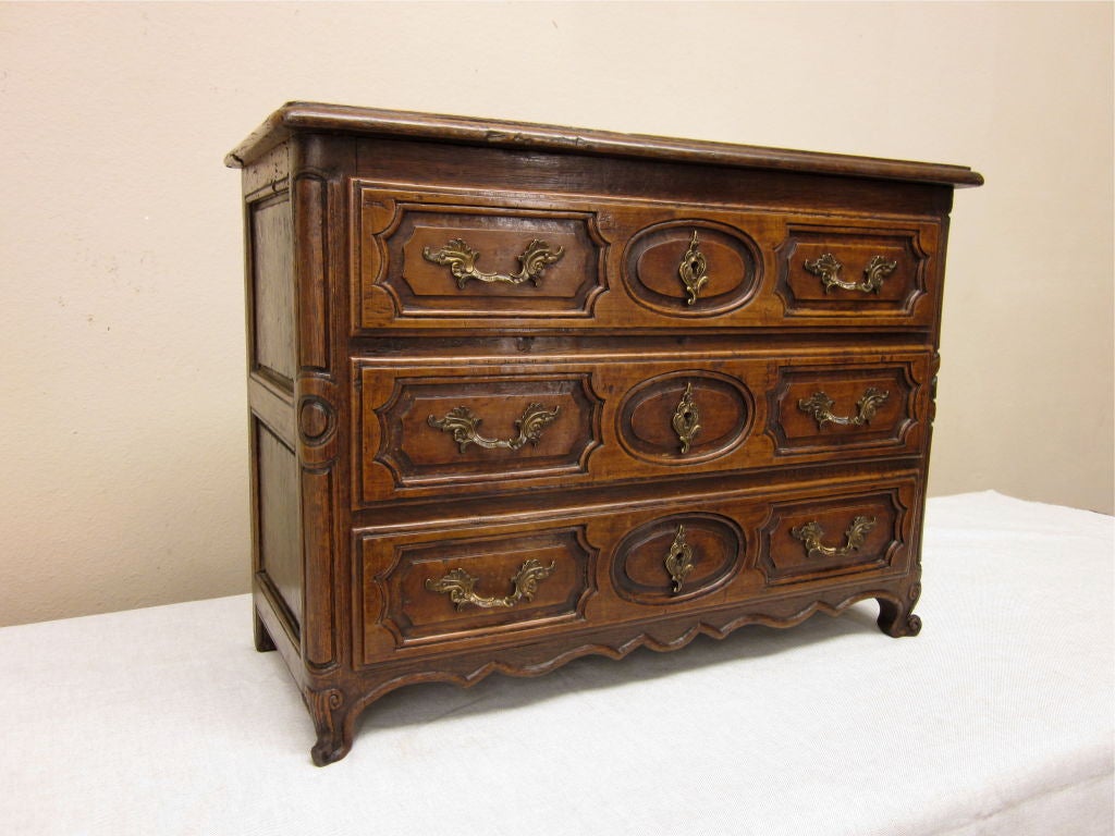 A wonderful walnut and oak three drawers miniature commode with original bronze hardware. Dovetailed drawer.
For many more fine antiques, please visit our online gallery at: www.ofleury.com