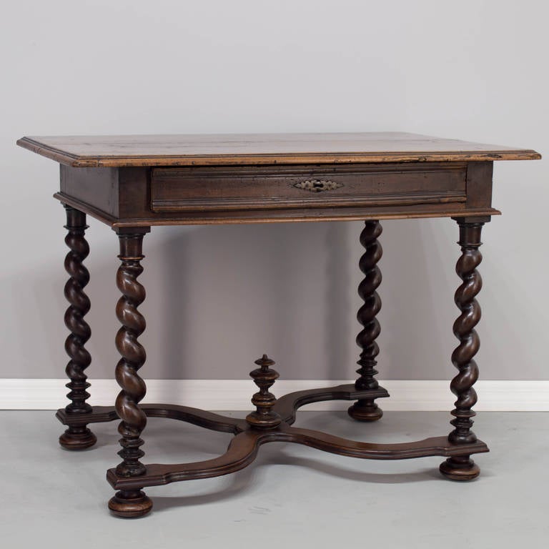 A Louis XIII style walnut side table with a dovetailed drawer, constructed with two planks of walnut on the top, four twisted turned legs ended with a bun feet, an "X" stretcher (restored), beautiful waxed patina. Original center