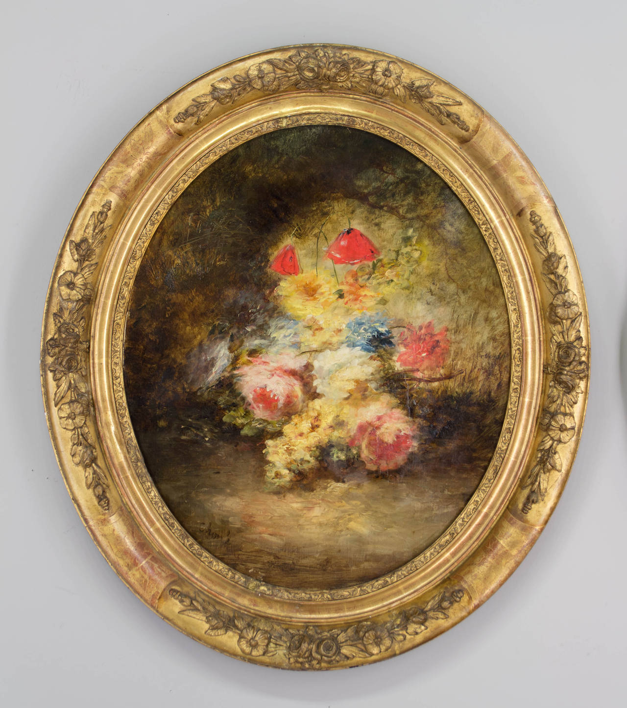 Pair of 19th c. French School colorful, decorative floral oil paintings in original carved and gilded oval frames. Artist signature lower left  Illegible.
Each canvas has been restored. Canvas size: 25