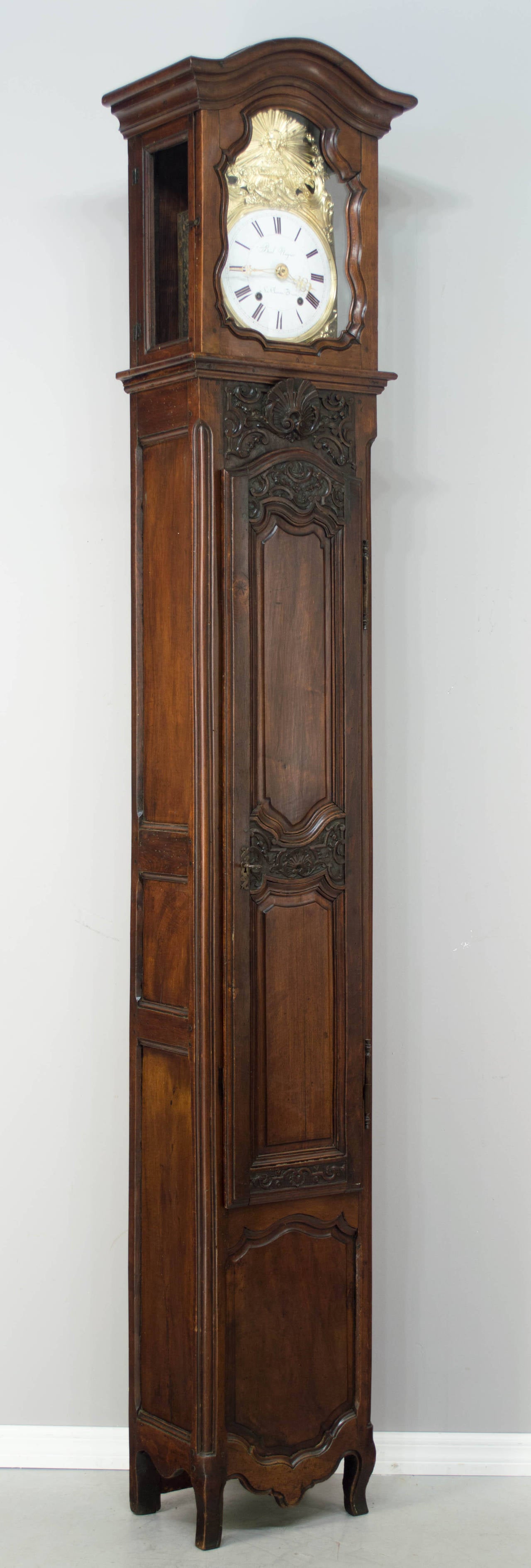 A splendid 19th century French Louis XV style Horloge De Parquet, or tall case clock, made of walnut with nice hand carvings and pegged construction. This grandfather clock is exceptionally tall, at almost nine feet. The case is in one piece with