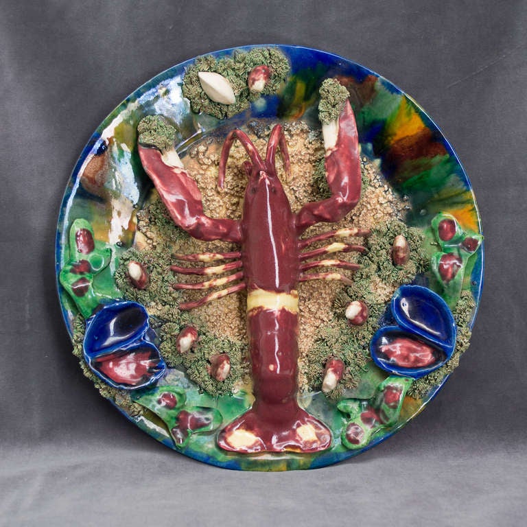 Exquisite color for this plate decorated in relief with a lobster and mussels and clam shells.  Signed 