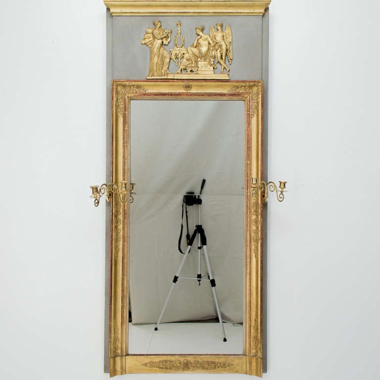 A superb partial painted and gilded trumeau with a two candle brass holder on either side. The mirror is in two sections.