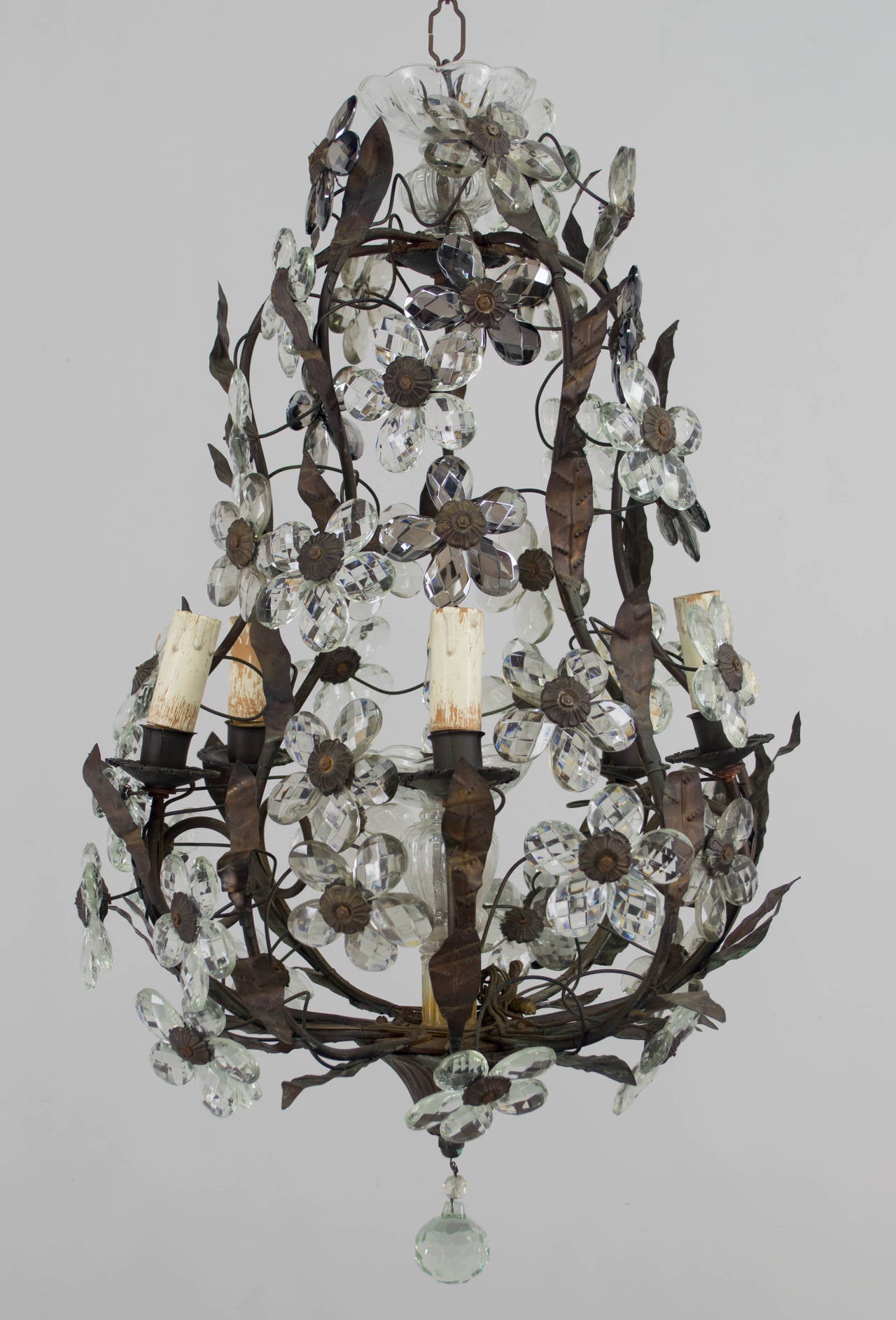 French six-light chandelier in the style of Maison Baguès, with faceted smoke glass prisms clustered into flower forms. Patinated brass, pear shaped frame with tole leaves. Height is 25.5