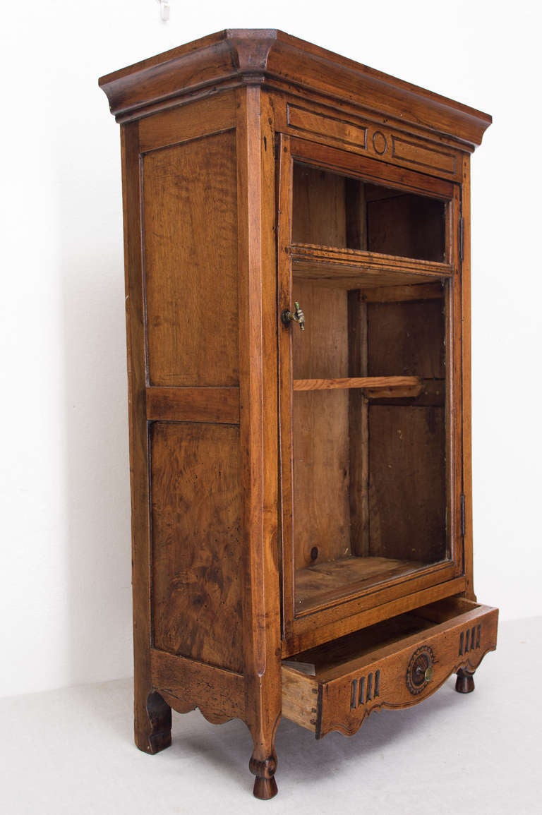 A good hanging vitrine from the Provence region made of walnut, pegged construction, original glass, having a bottom drawer. Brass hardware is original. This vitrine is to he hung.