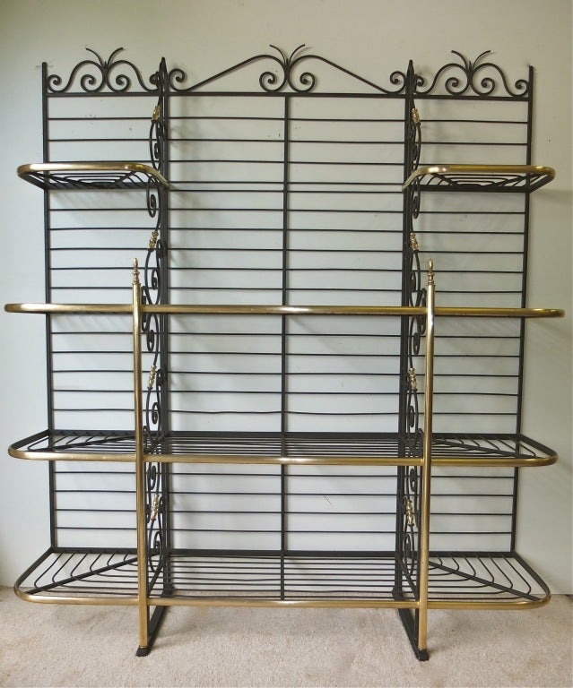A stunning French Bakers Rack in iron and brass.  Finely turned brass finials adorn scrolled iron on this 4 tiered rack.