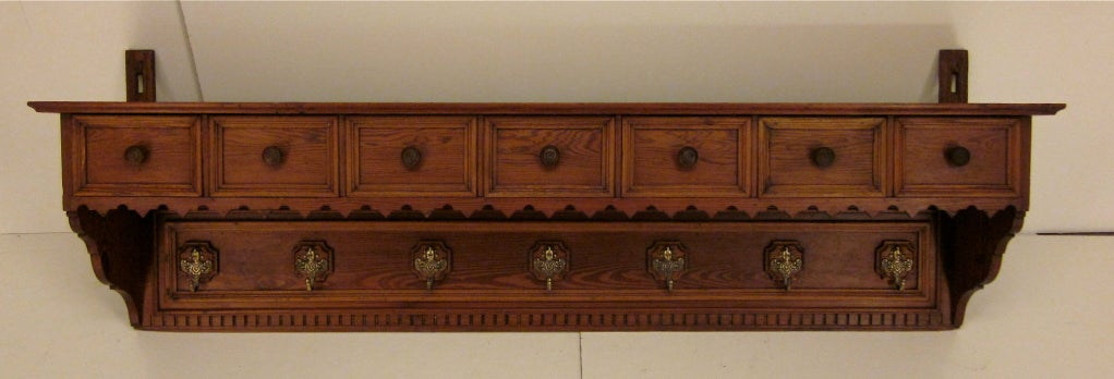 A great shelf made of pitch pine with seven drawers and brass hooks. Hardware original.