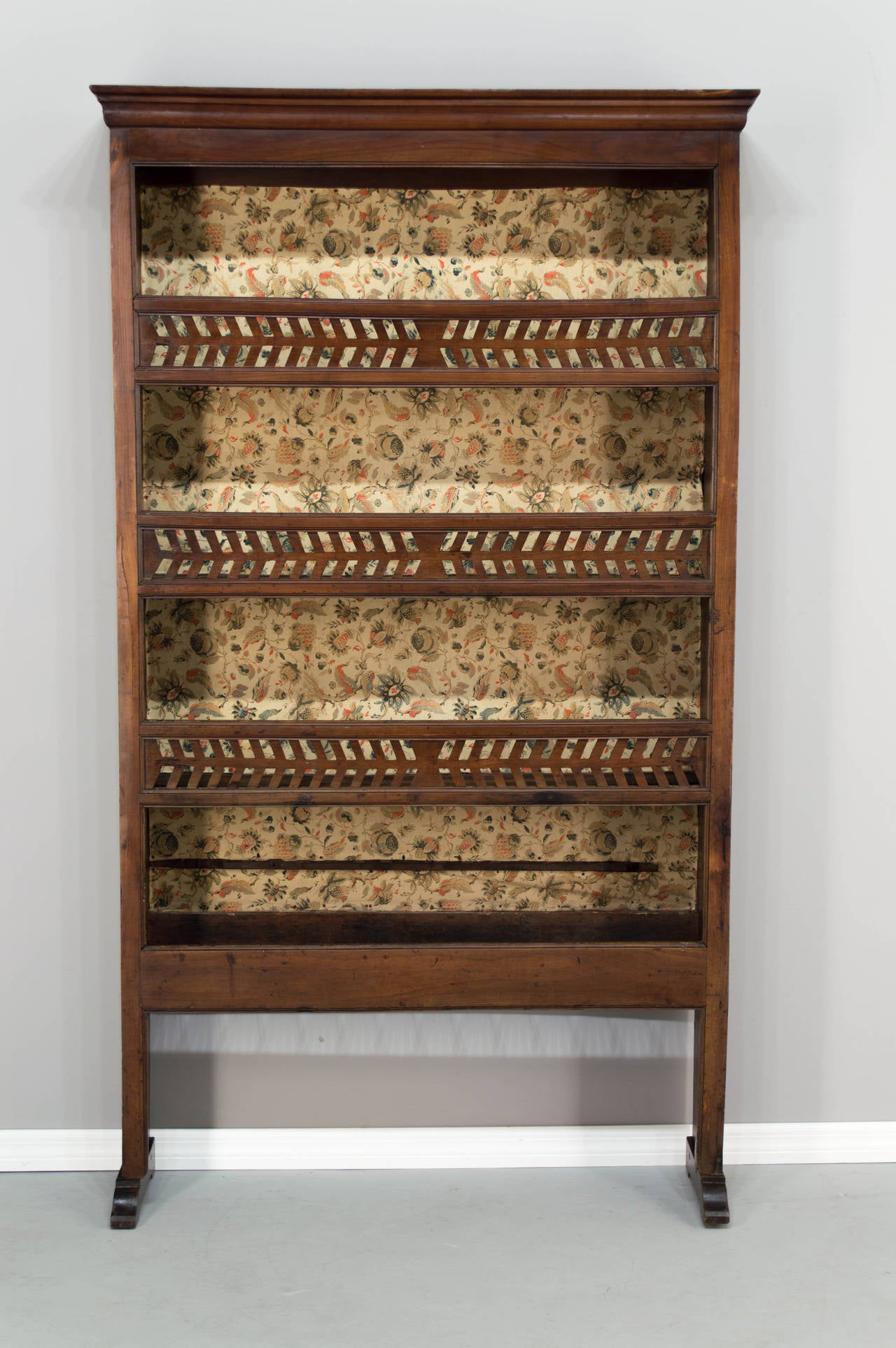An original plate rack from the Brittany province made of cherry and chestnut with three shelves for displaying some dishes with a carved front gallery representing a fish bones and a lower shelf for drying some dishes with a spoon holder. All