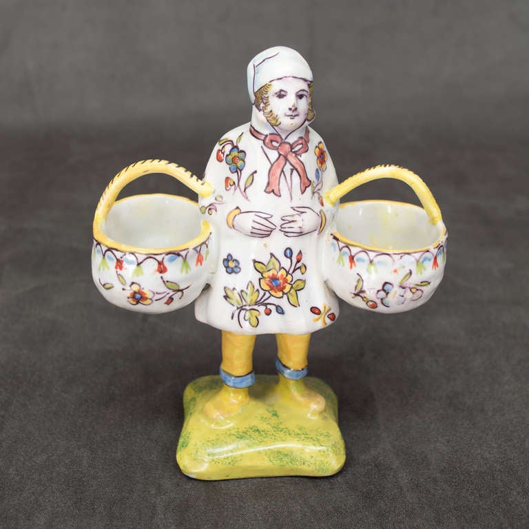 A figurine of a man holding two baskets, faience of Desvres, with mark of Rouen on the bottom.