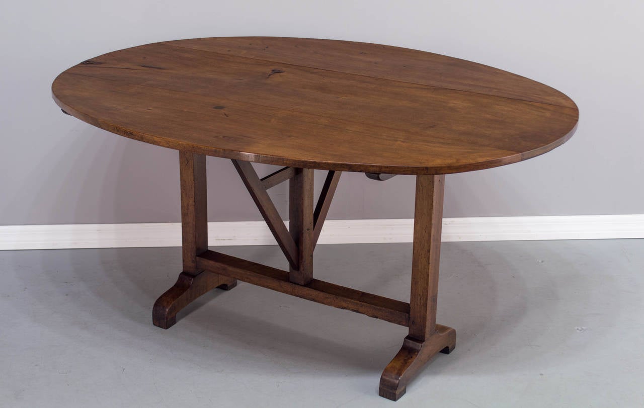 A 19th century wine tasting table made of solid walnut, having the top constructed of three planks, a typical base with pegged and mortise construction. Note the feet have been raised about 1.5