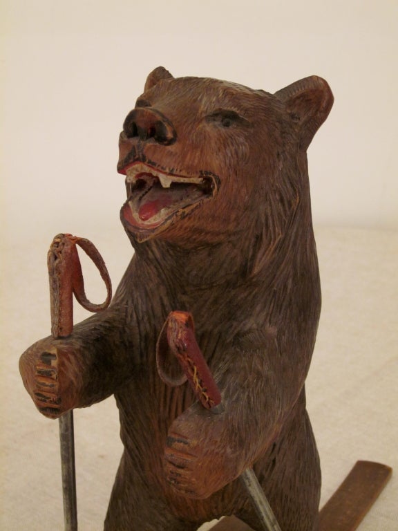 A bear carved in linden with walnut skis and iron pole.