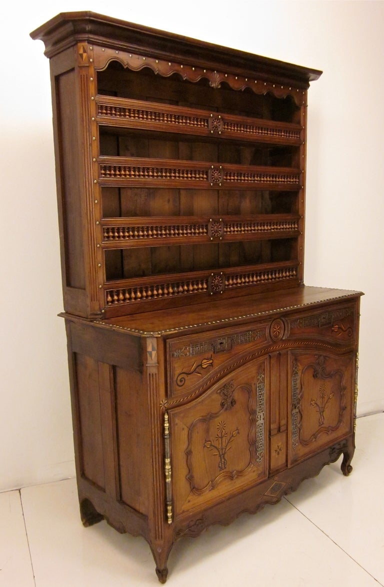 A stunning vaisellier from the Brittany province made of chestnut and oak with brass nails decoration and inlay on the panels of the doors and the drawers. Height of the buffet part is 39.75