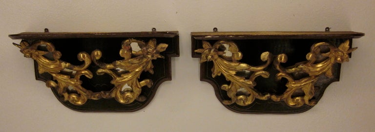A pair of Italian sconces with a dark green paint and carved gilt wood with mirror. Great color and finely carved. One mirror replaced on one sconce.