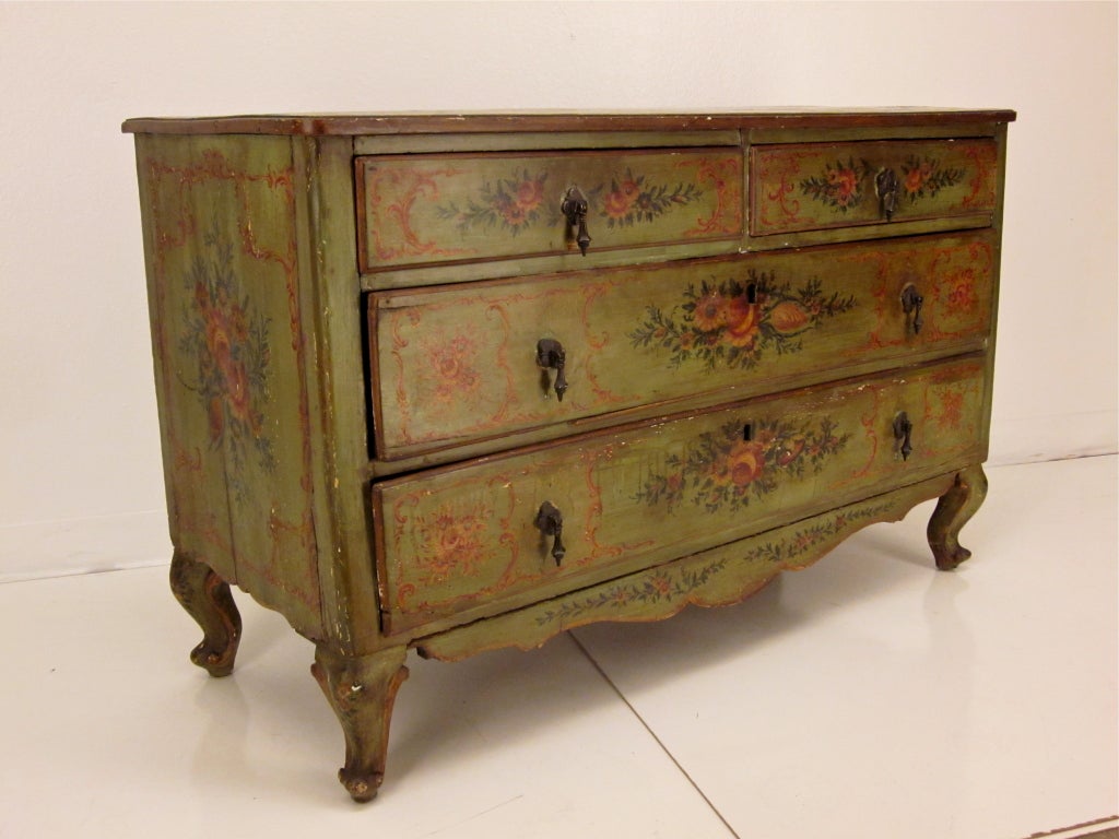 A good 18th century painted pine commode with four drawers with floral motif from Italy.