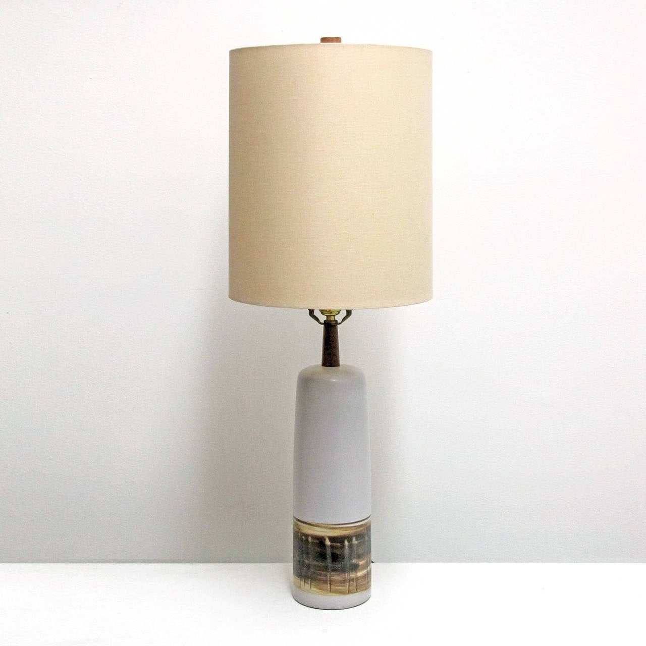 Large-scale soft gray and white satin finish ceramic table lamp by Marshall Studios, broad textured band along the lower third, Gordon Martz's signature details of walnut necks and finial, signed.