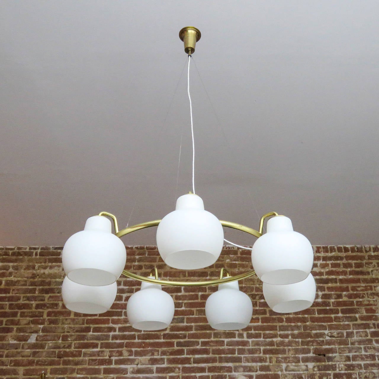 stunning, large scale Christiansborg / B&G Ring Chandelier by Vilhelm Lauritzen, with seven white opaline glass shades on a circular brass frame suspended from cables, height is adjustable