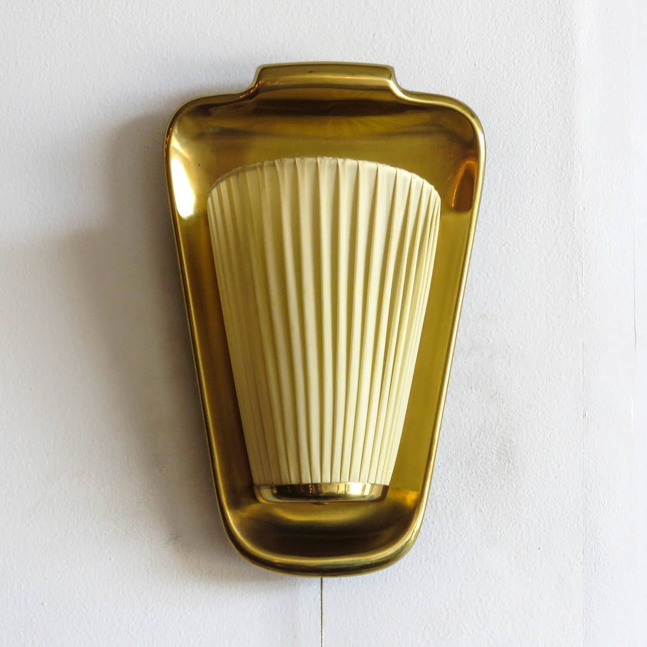 Wonderful pair of 1950s German wall sconces in brass with original pleated cloth shades, individual on and off switches.