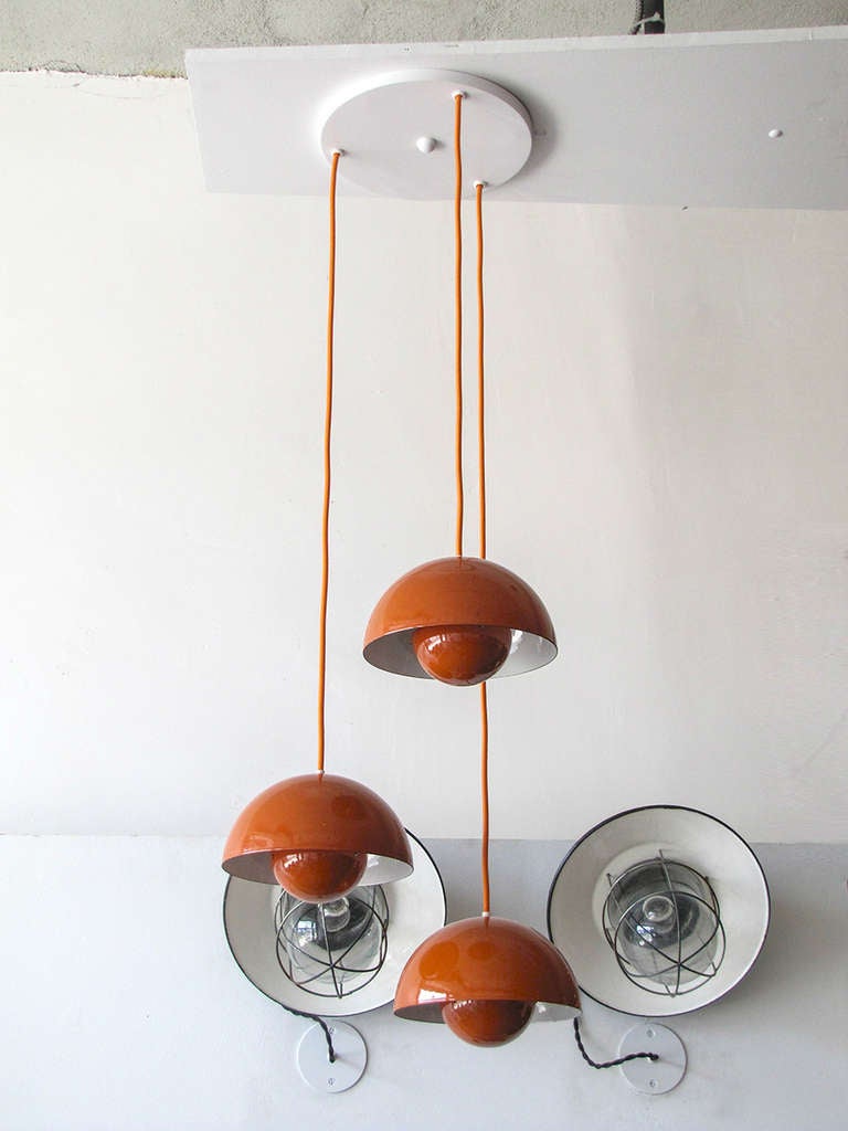 wonderful 1970's Flower Pot hanging lights by Verner Panton for Louis Poulsen, three orange enameled pieces with matching colored cords on a single canopy, insides of the reflector spheres is orange, heights are adjustable, a total of ten individual