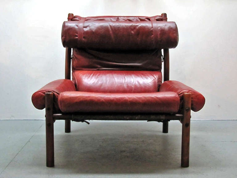 stunning comfortable lounge chair by Arne Norell, solid rosewood frame, seat and back of black saddle back leather, cushions in original red leather