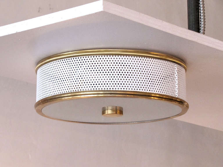 elegant flush mount ceiling lights attributed to Mathieu Mategot, perforated enameled metal ring with brass rims and sandblasted glass disc

*One light has sold. This is for the one remaining light.