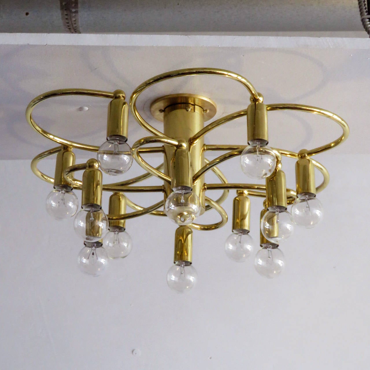 Stunning brass twelve-light flush mount ceiling light by Honsel Germany with two tiers of six organically shaped arms, with a total of 12 sockets total, can be used as wall sconce as well.