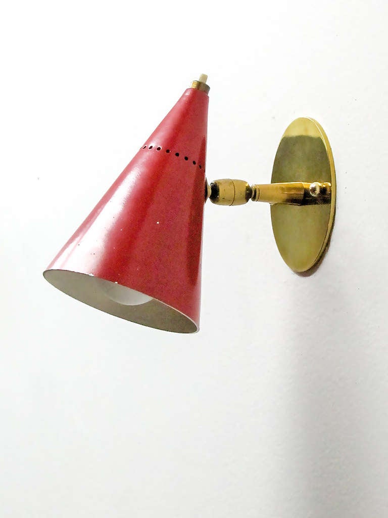 minimalistic italian wall lamps in brass with multipositional red cone shades