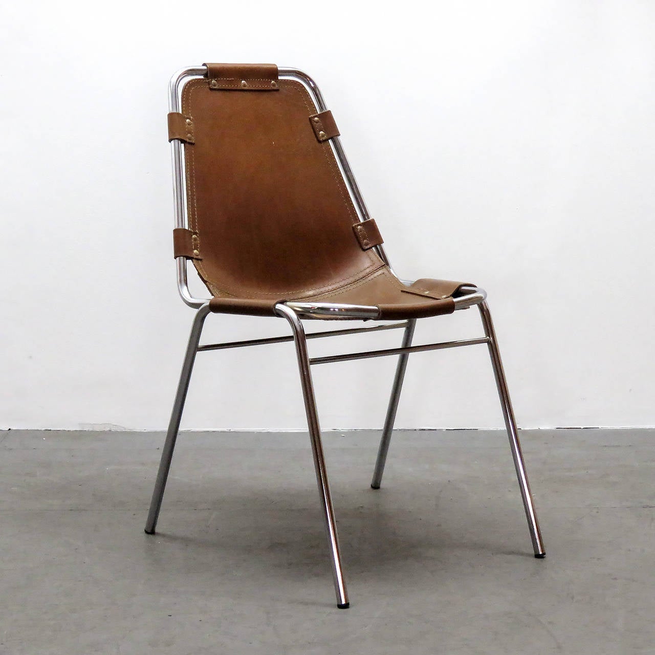 Iconic leather and metal side chair by Charlotte Perriand for the Ski resort Les Arcs in 1960, with chrome tubular frame in great condition and high quality thick leather seat with a fantastic patina to the leather.