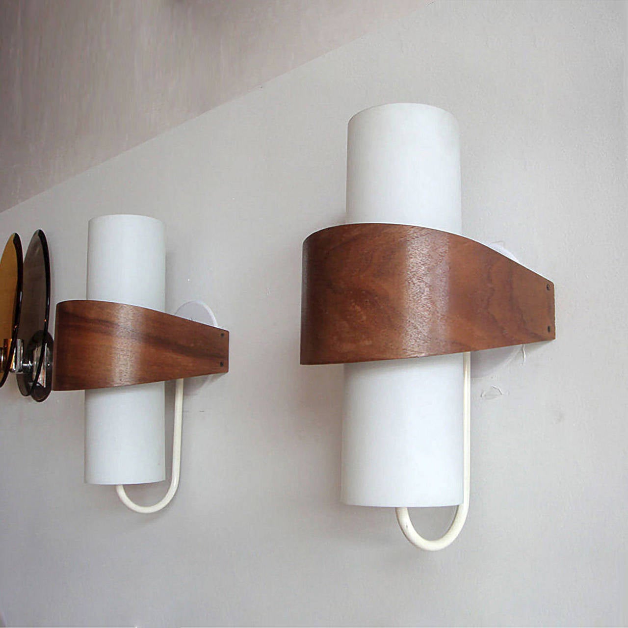 Elegant geometric sconces composed of opaque glass cylinders with a teak veneer wrap. Priced individually.