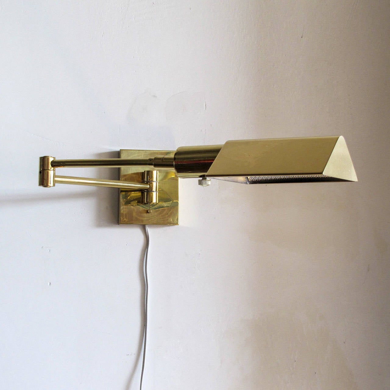 Pair of adjustable brass swing arm wall lamps by Koch & Lowy, brass bodies and hoods, adjustable vertically and swivel for optimal light direction, dimmable, stamped 