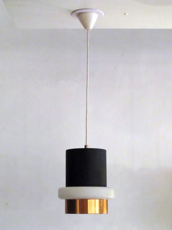 elegant cylindrical Philips pendant light<br />
with a translucent milk glass belt held by a copper skirt