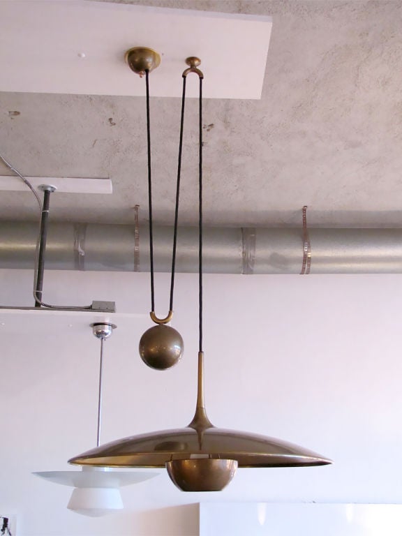 large brass saucer with pully mechanism<br />
a HEAVY brass ball counter balances the weight <br />
of the fully adjustable shade