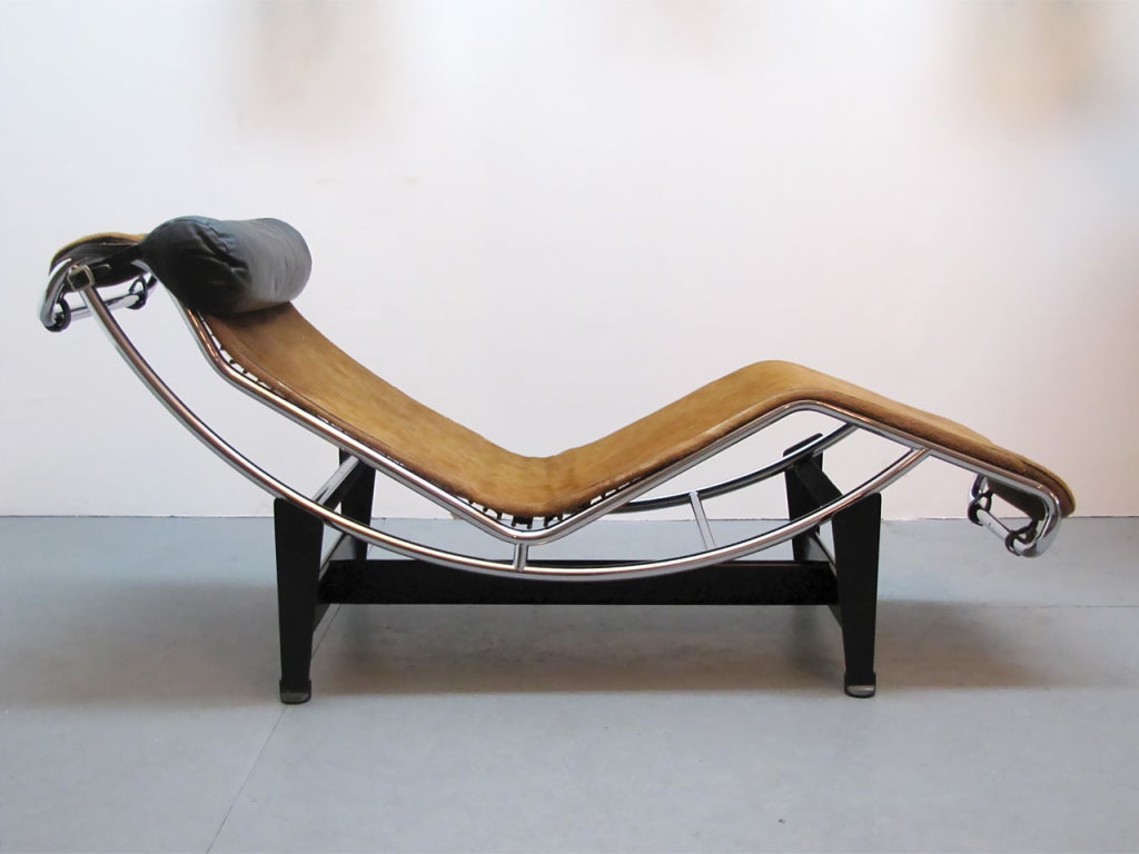 early Cassina edition LC-4 chaise longue designed by Le Corbusier. Signed and stamped with maker's markings. Features a matte black steel base, with a tubular steel and original cowhide leather upholstery with black leather headrest. Fully