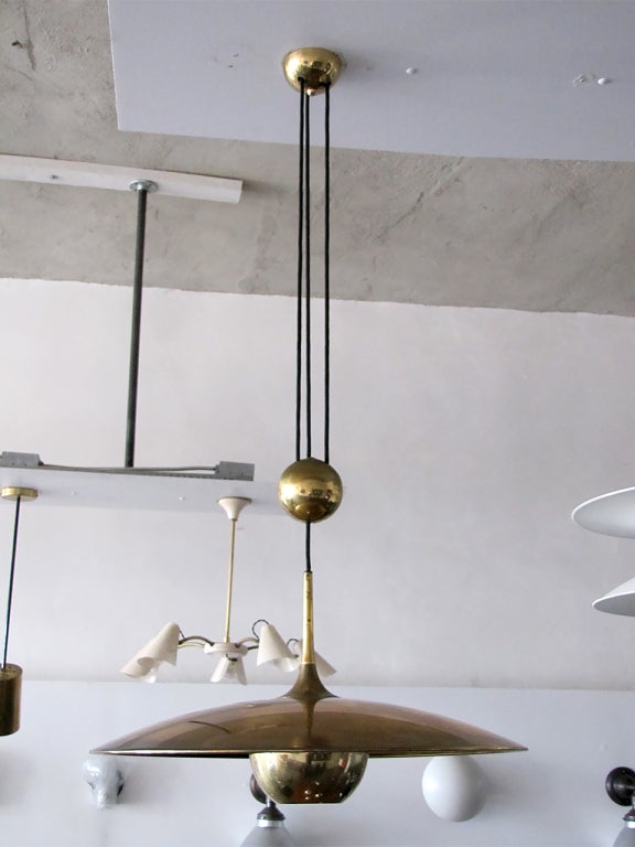 large brass saucer with pully mechanism
a HEAVY brass ball counter balances the weight
of the fully adjustable shade