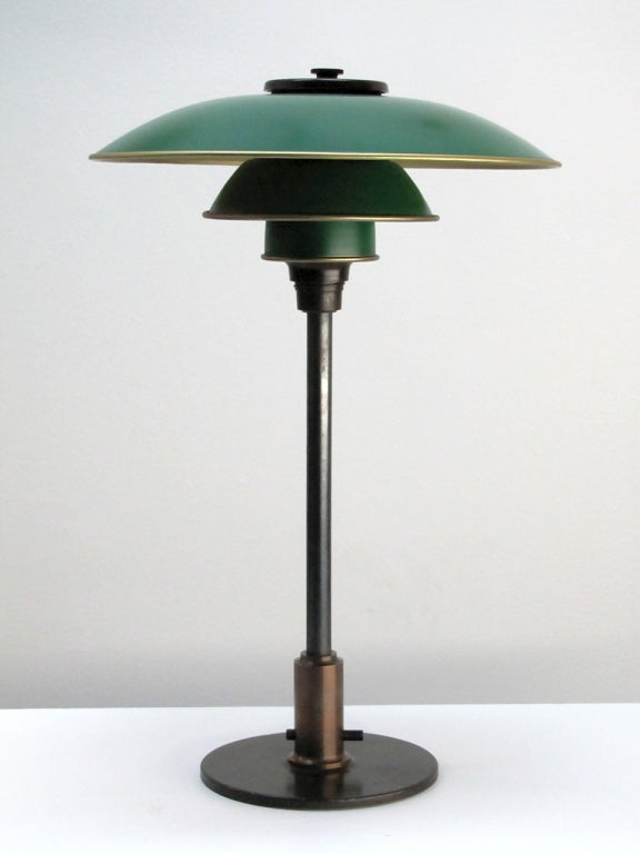 wonderful early table lamp by Poul Henningsen for Louis Poulsen
patinaed brass hardware with bakelite top cover
mounted with 3/2 green & golden enameled shade set
through switch above the base, stamped 'Pat. Appl.'