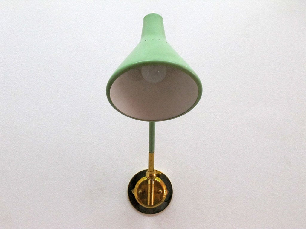 wonderful brass and enameled metal sconce by Stilux, perforated, articulating hood, height and direction fully adjustable, on/off switch on the hood, matching yellow table lamp available