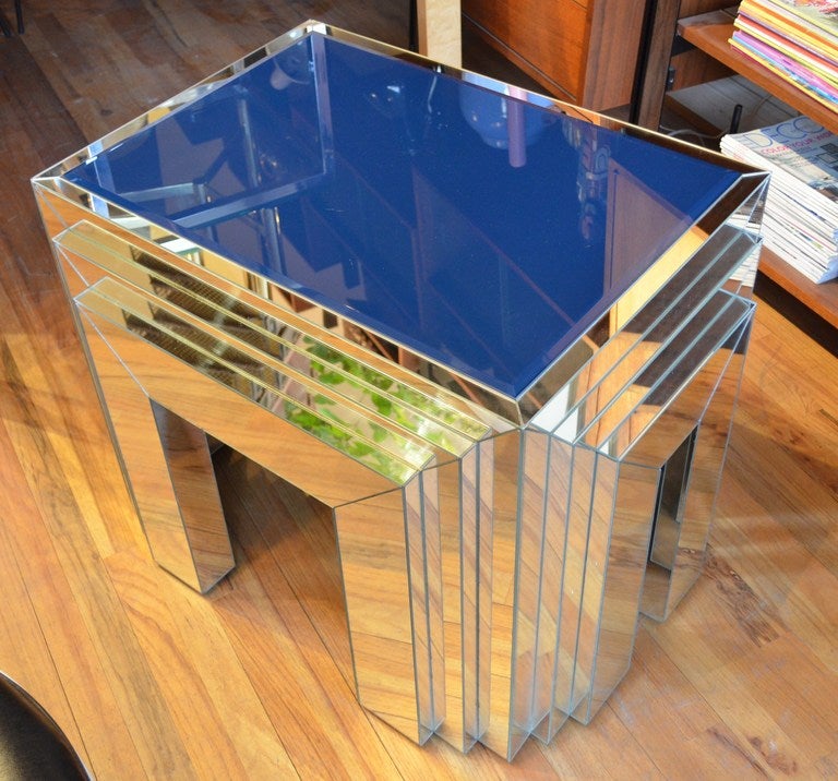A deco inspired 1970s mirrored end table with blue opaque glass top.