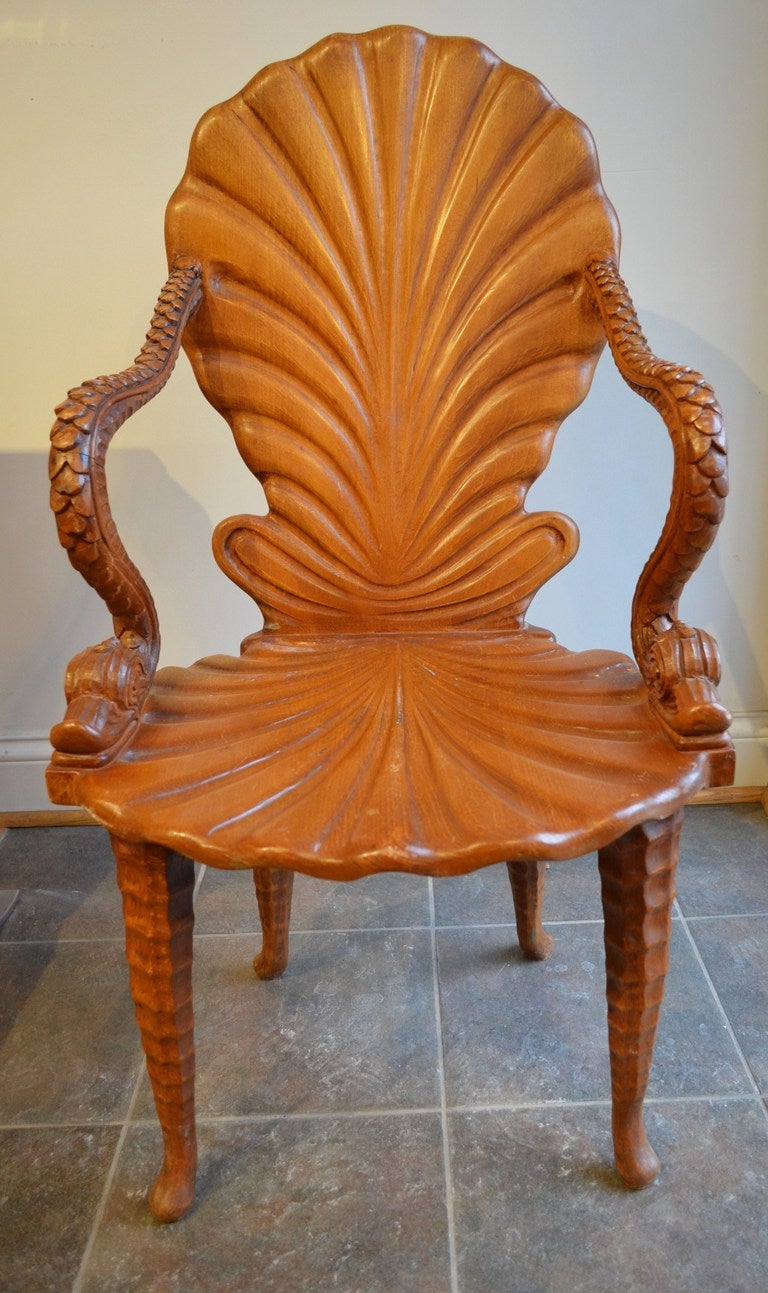 A Classic interpretation of a 19th century Italian Grotto chair. The chair has a carved shell formed seat and back with dolphin arms.