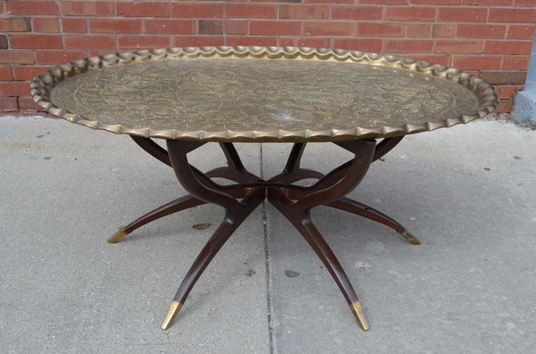 This stunning oval coffee table features an antique Persian hand-hammered tray with a thick pie crust edge. The etchings include chestnuts and leaves. The spider leg base has brass sabots.
P