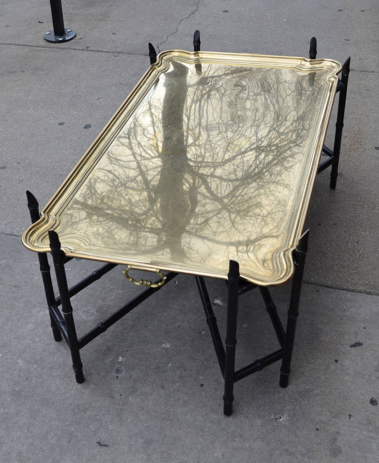A monumental German heavy brass tray coffee table on a wood bamboo base.