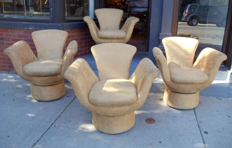A marvelous set of four highly sculptural tulip shaped swivel chairs.
The chairs are upholstered in their original suede. They are worn and will need to be reupholstered.

