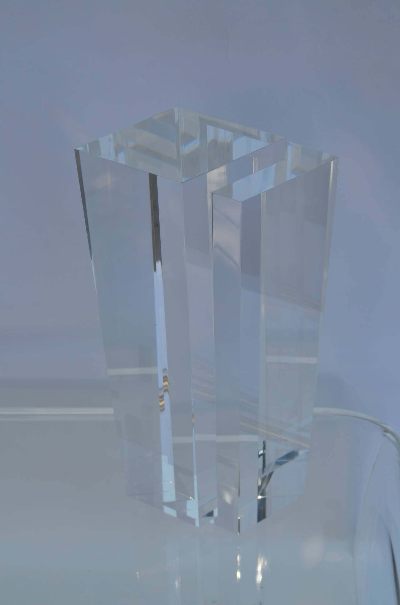 A tall Lucite skyscraper sculpture.
The acrylic is crystal clear.
Its sharp geometric lines and prismatic shape is
attractive from all angles.
Pictures do not convey the sharpness of the piece.