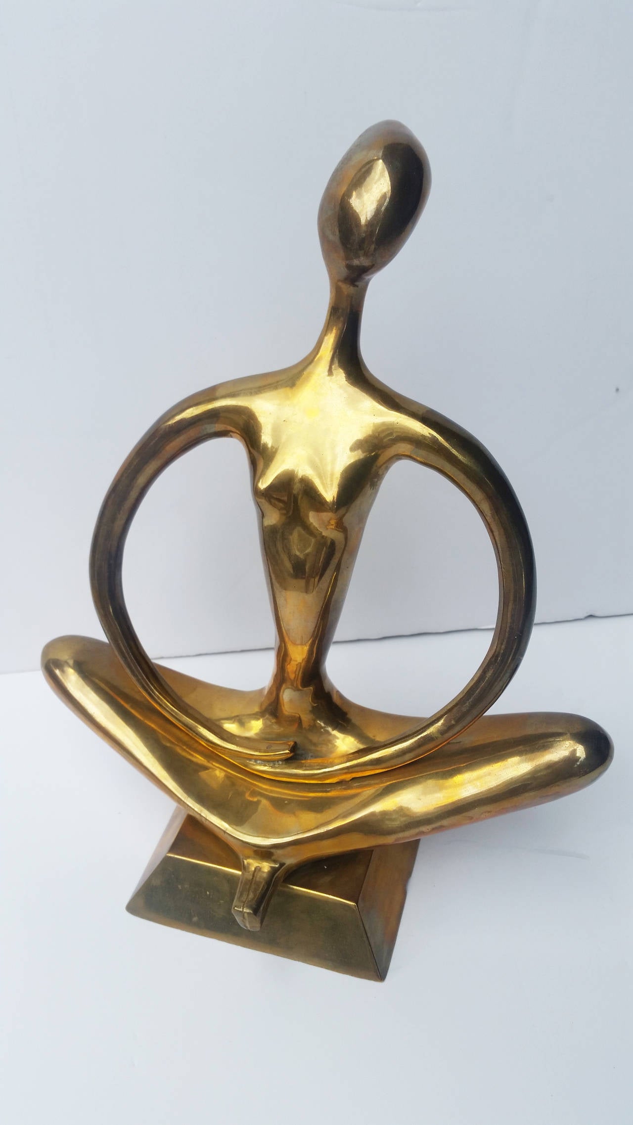 An organic brass mid-century sculpture of a woman
in the Classic Lotus pose. Great from all angles.
The art sits on a raised brass base with beveled edges.