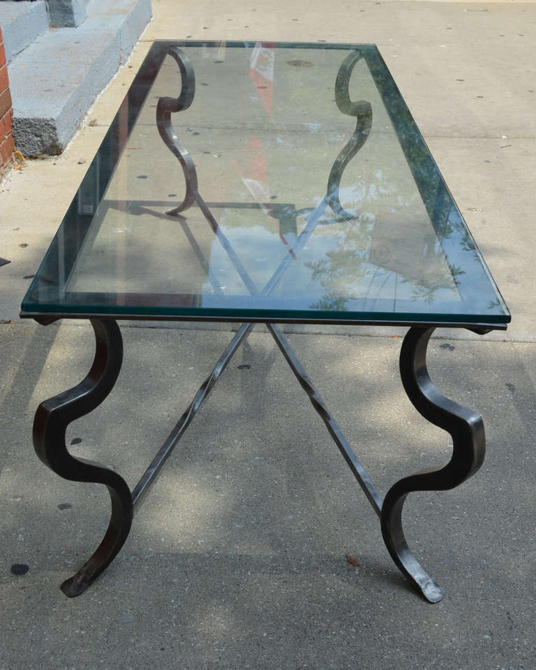 Polished steel coffee table on cabriole legs with a glass top.
The table has a distinct Industrial feel.