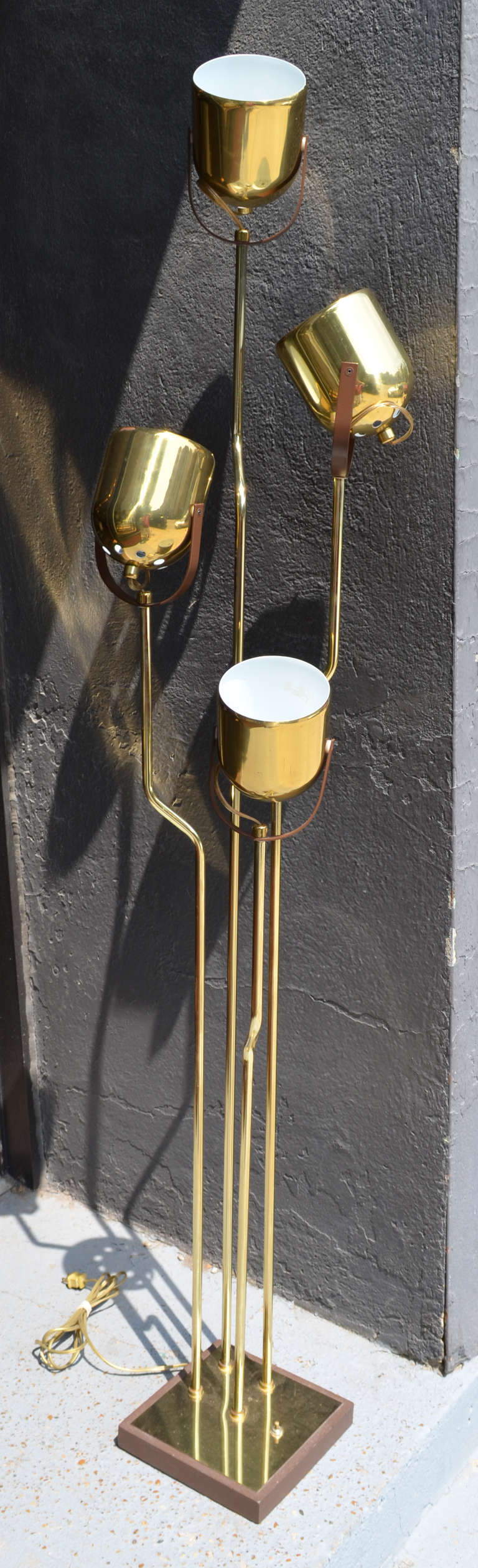 A four arm brass floor lamp . The arms are various hights surmounted by adjustable brass pendant adjustable domes. The adjustable domes make for great reading ,accent or ambient lighting. Highly versatile lamp.