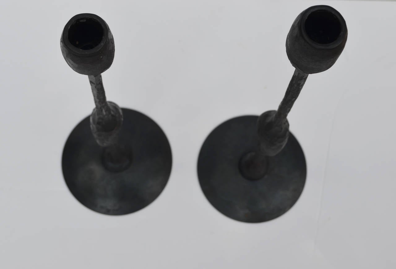 A pair of hand-forged steel Brutalist candlesticks. One 
candlestick is 17 inches high and the other is 16 inches.
The two are signed and dated 1993. The signature is not
legible.