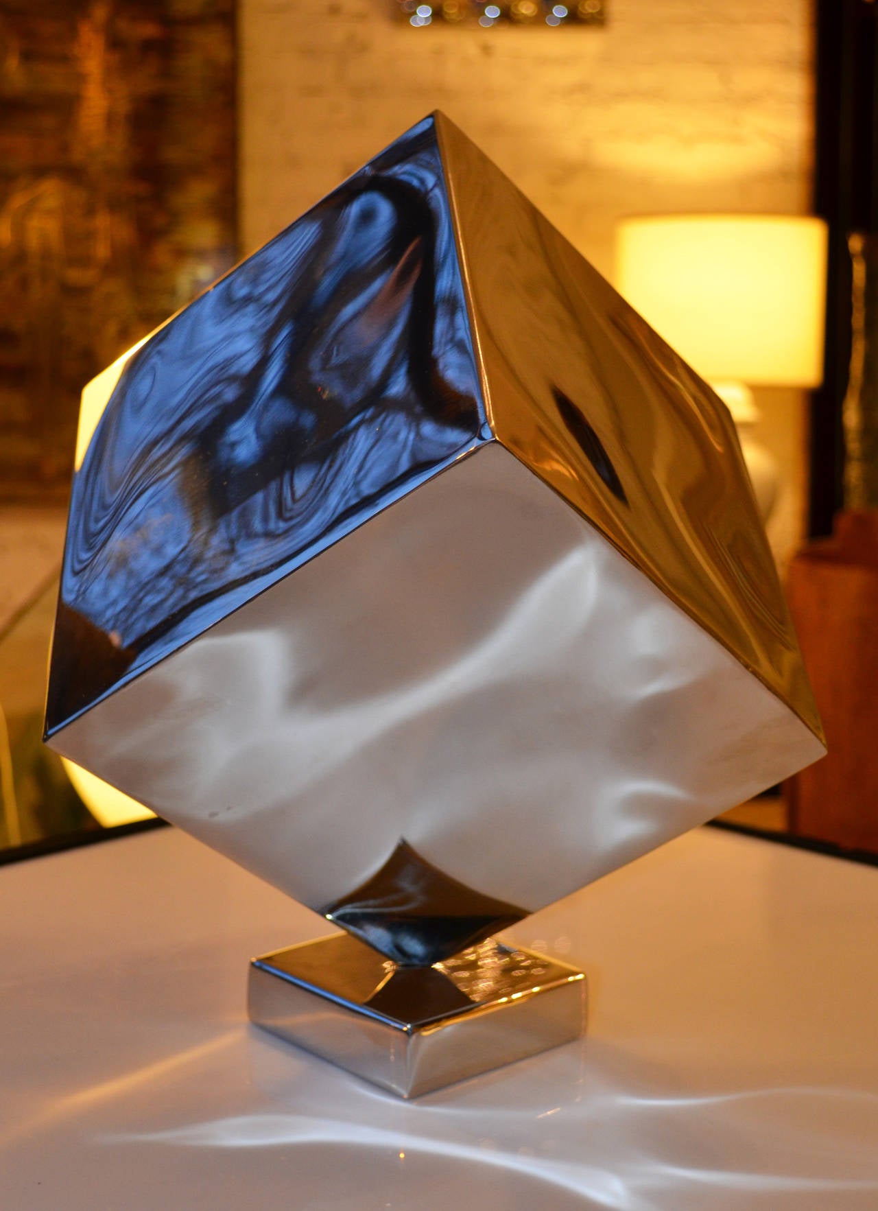 Una potente scultura modernista a forma di cubo cromato.