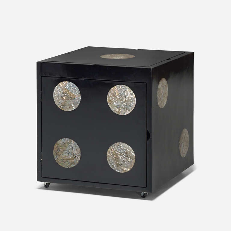 This rolling table features an interchangeable top, with three game board options including chess, Chinese checkers and backgammon and one blank tabletop; top opens to reveal open storage.