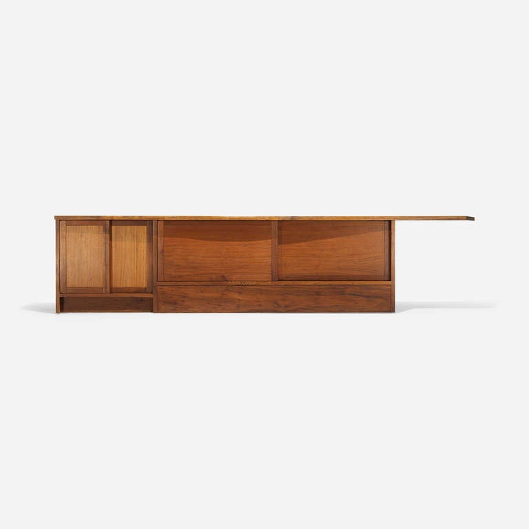 Expressive asymmetrical composition with a cantilevered top, dovetail joinery, sap grain details and overhanging free edge; headboard features four sliding doors concealing a single adjustable shelf and storage. Sold with copies of original drawings