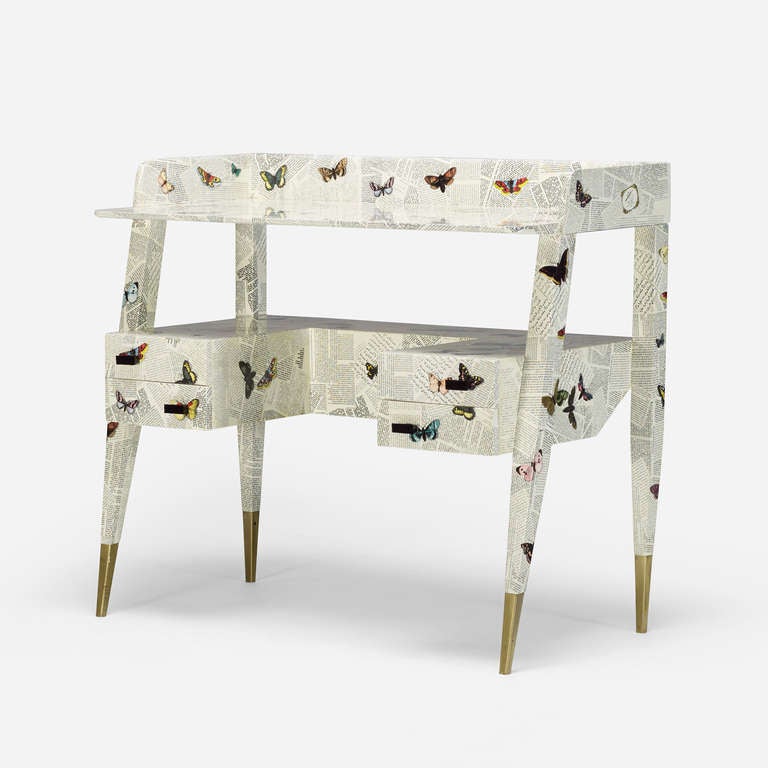 Piero Fornasetti and Gio Ponti originally collaborated on this desk design in the 1950s. This example featuring the <i>Oggetti sparsi e farfalle su giornali</i> pattern is one of few examples produced by Fornasetti Milano in the 1990s. Signed with