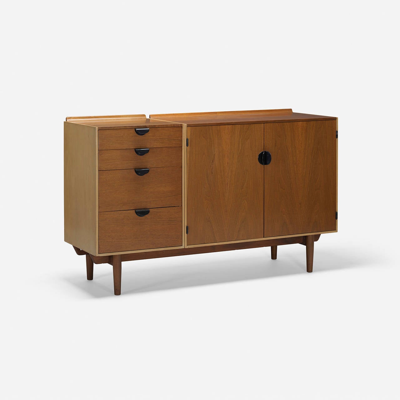 Cabinet features four drawers and two doors concealing two drawers and two adjustable shelves. Signed with applied metal manufacturer's label to drawer: [Baker Furniture].